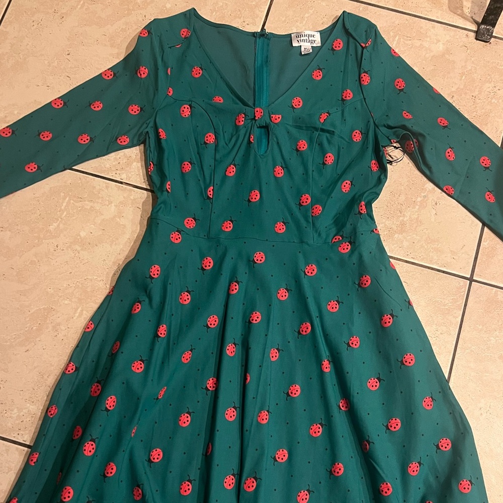 Adorable green dress with lady bug print and key hole bust detail.